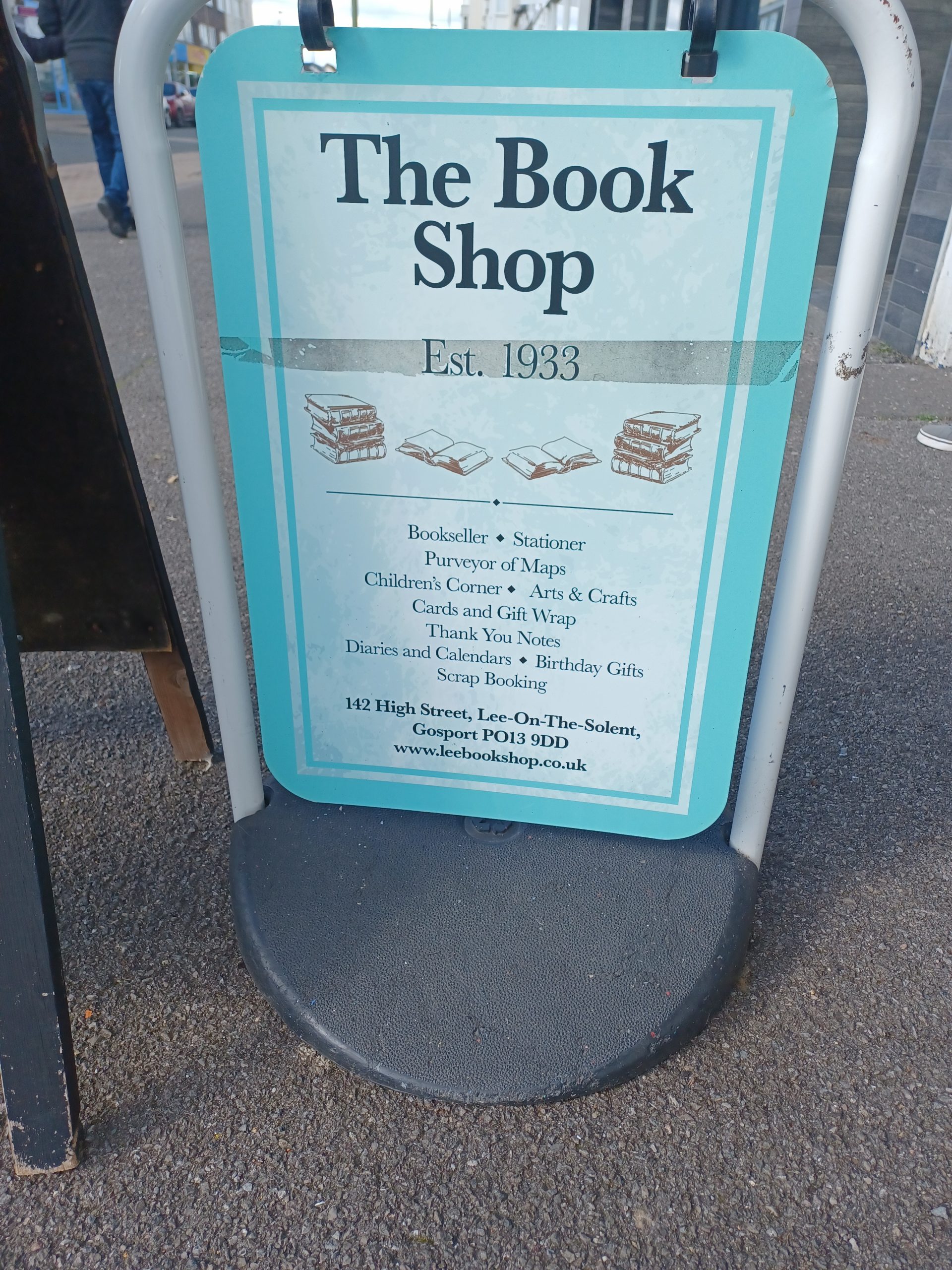 A sign standing on the pavement advertises The Book Shop, established 1933